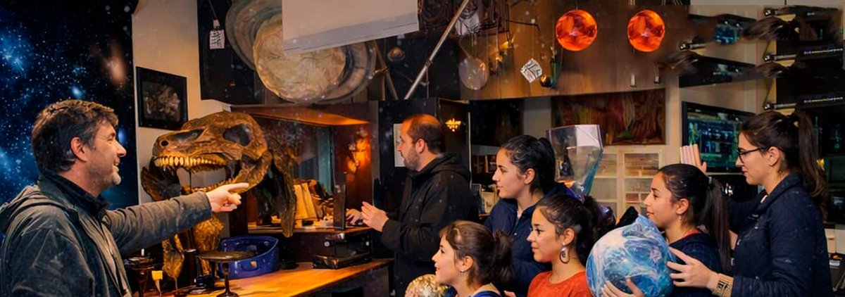Gu&iacute;a mostrando piezas de la exposici&oacute;n a una familia en el Planetario CIASIVE
