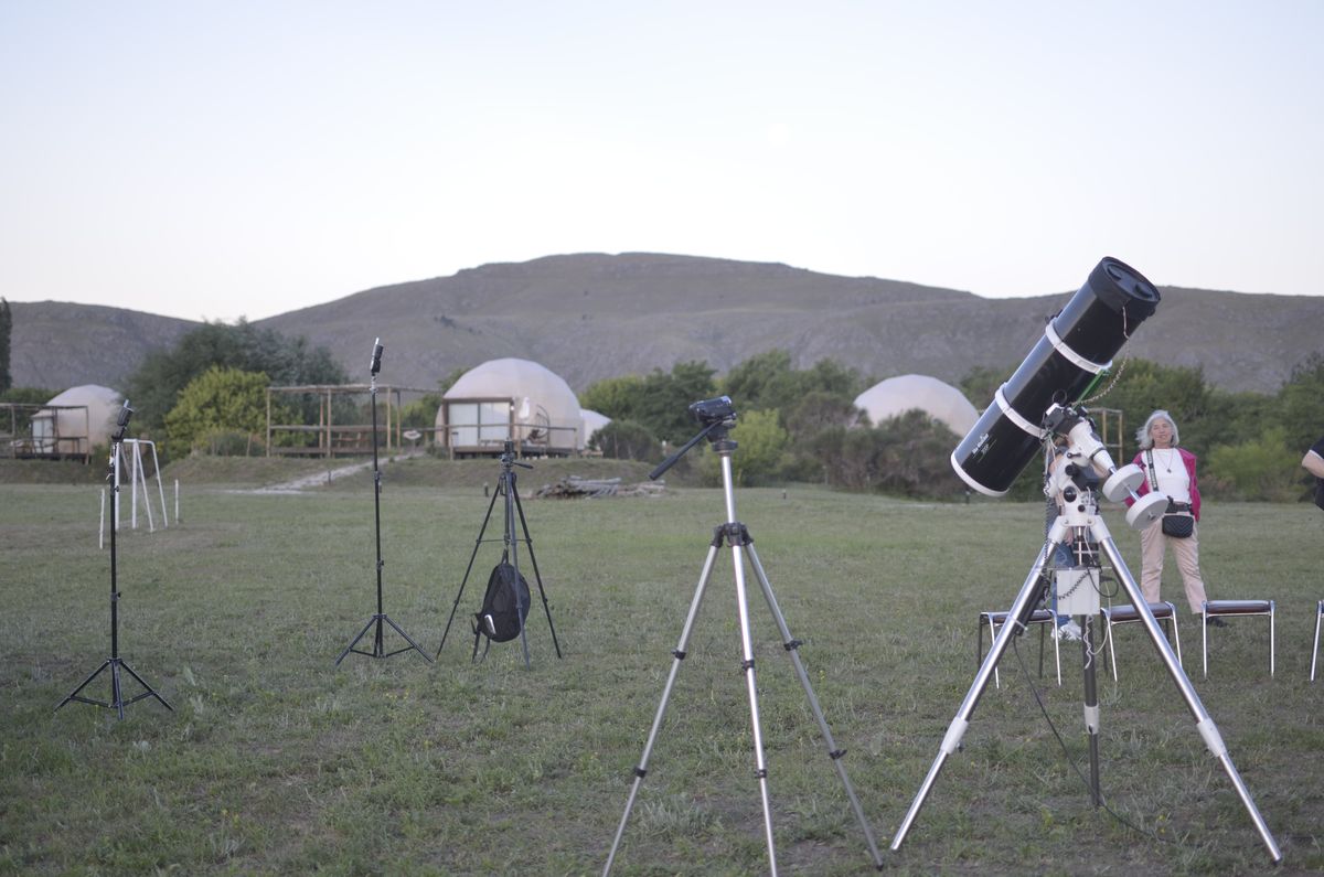 Telescopios instalados en el campo frente a los domos de Puente Blanco Glamping